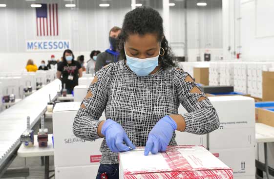 Warehouse employee packing Johnson and Johnson vaccine for shipment
