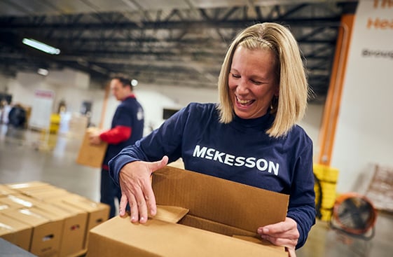A McKesson warehouse employee sealing a box