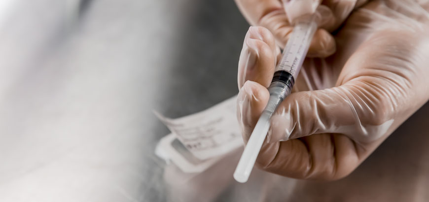 A closeup of a doctor holding an intravenous needle