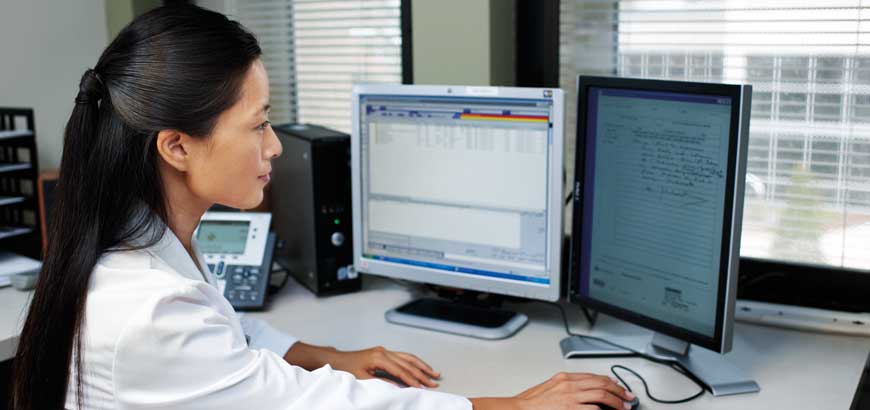 A pharmacist working at a computer workstation