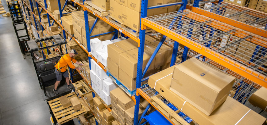 A McKesson warehouse employee restocks the shelves with large boxes