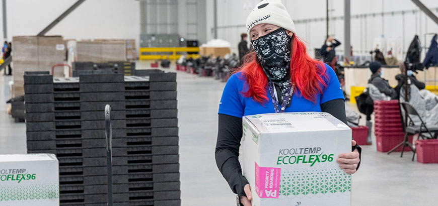 A worker carrying a box in a distribution center