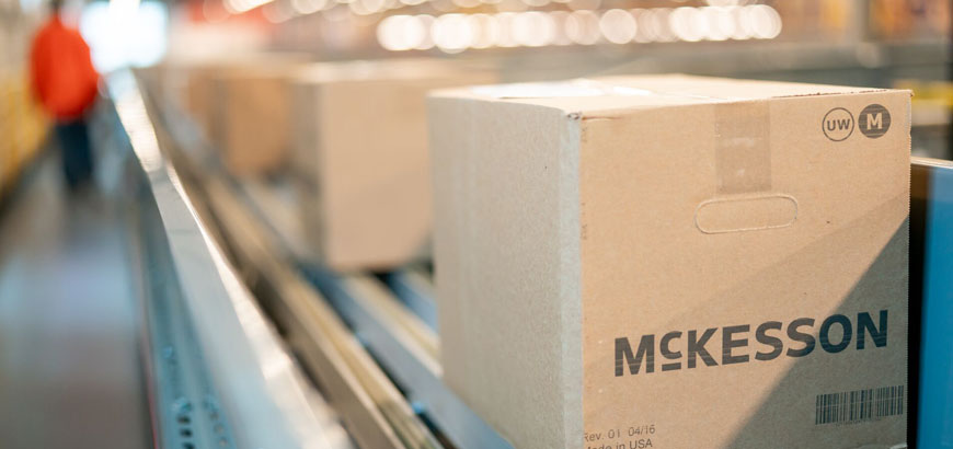 Close up of a shipping box with McKesson logo on it sitting on a conveyor belt.