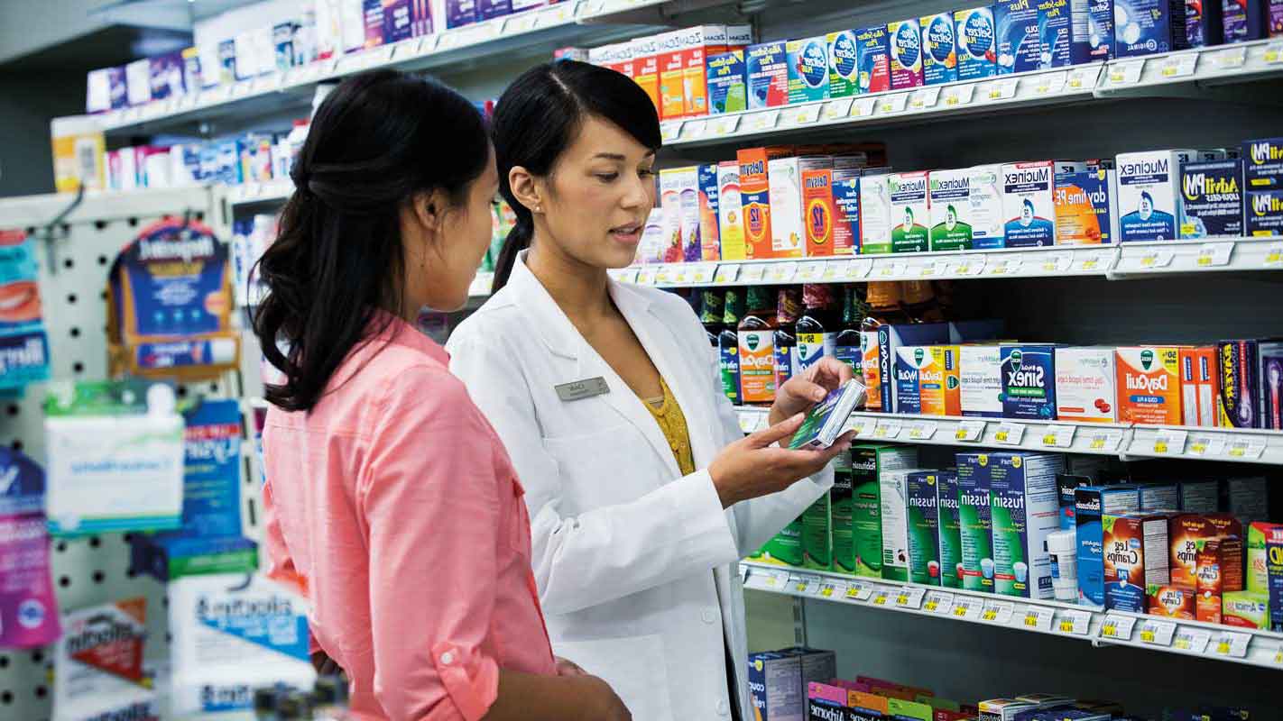A pharmacist speaking to a customer about medication