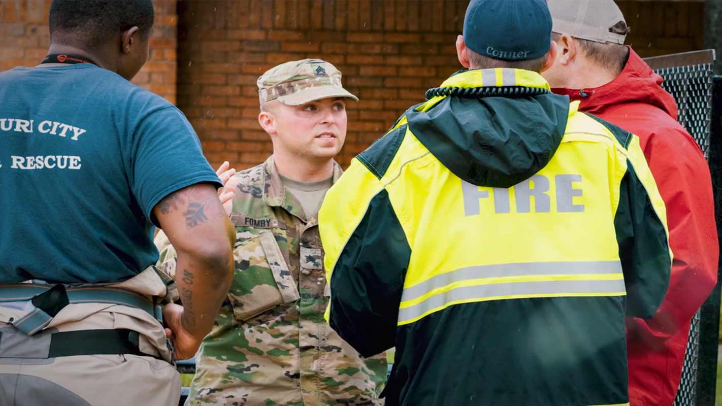 A member of the military talking to firefighters