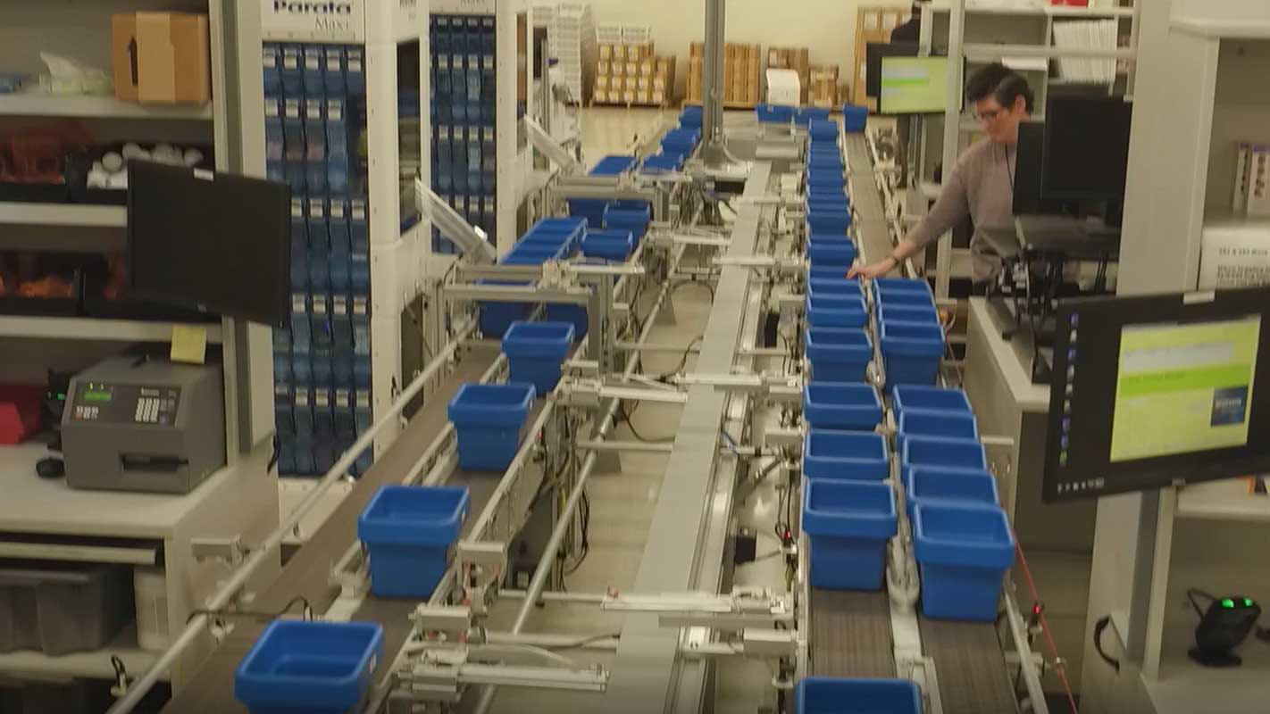 Assembly line with blue containers on the belt