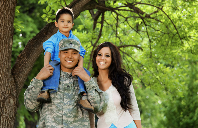 Image of family standing together, the father is wearing a military uniform