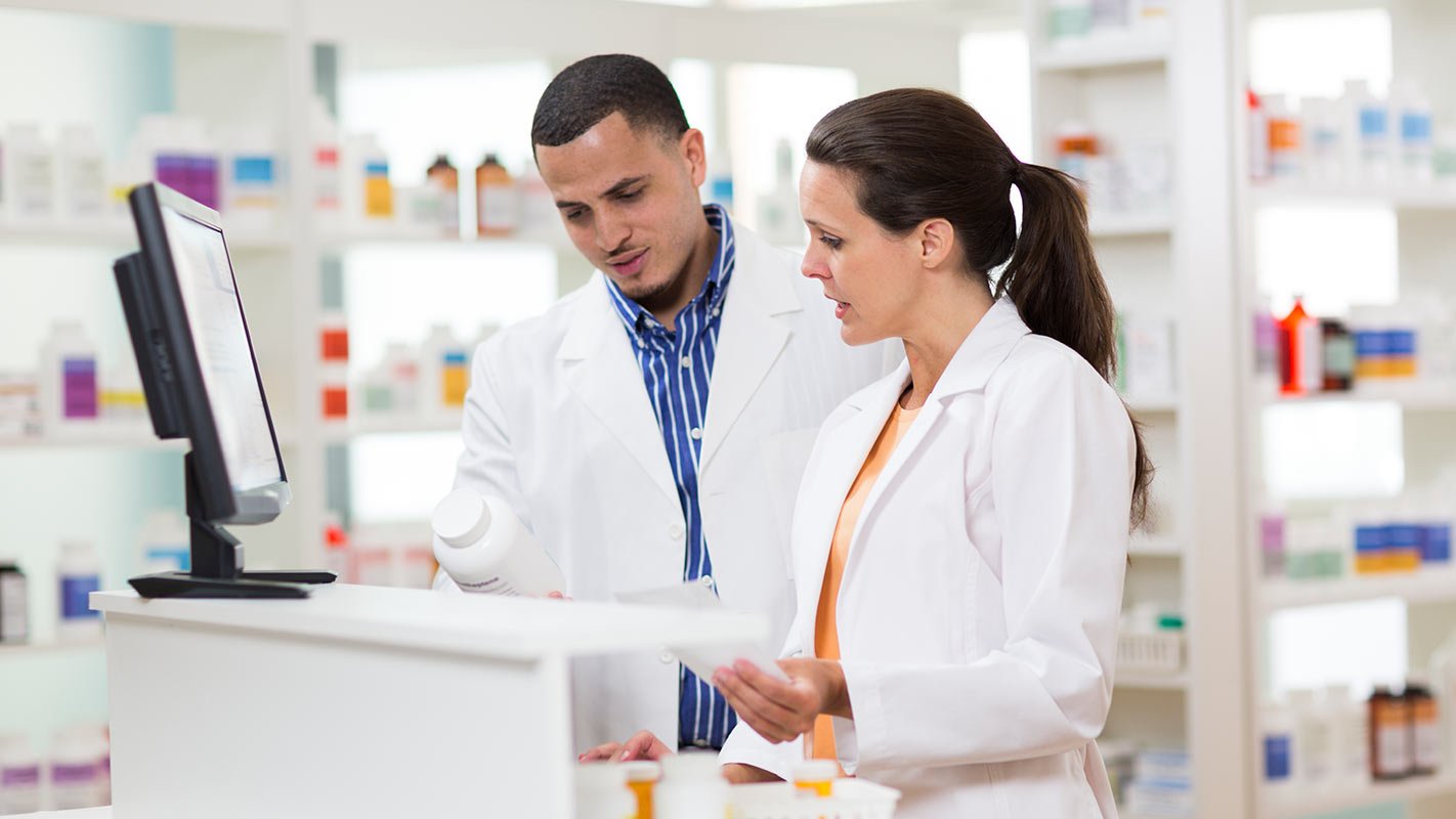 Two pharmacists looking at a prescription pill bottle