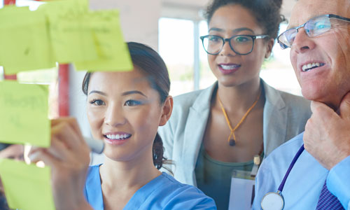 A group of people looking at sticky notes